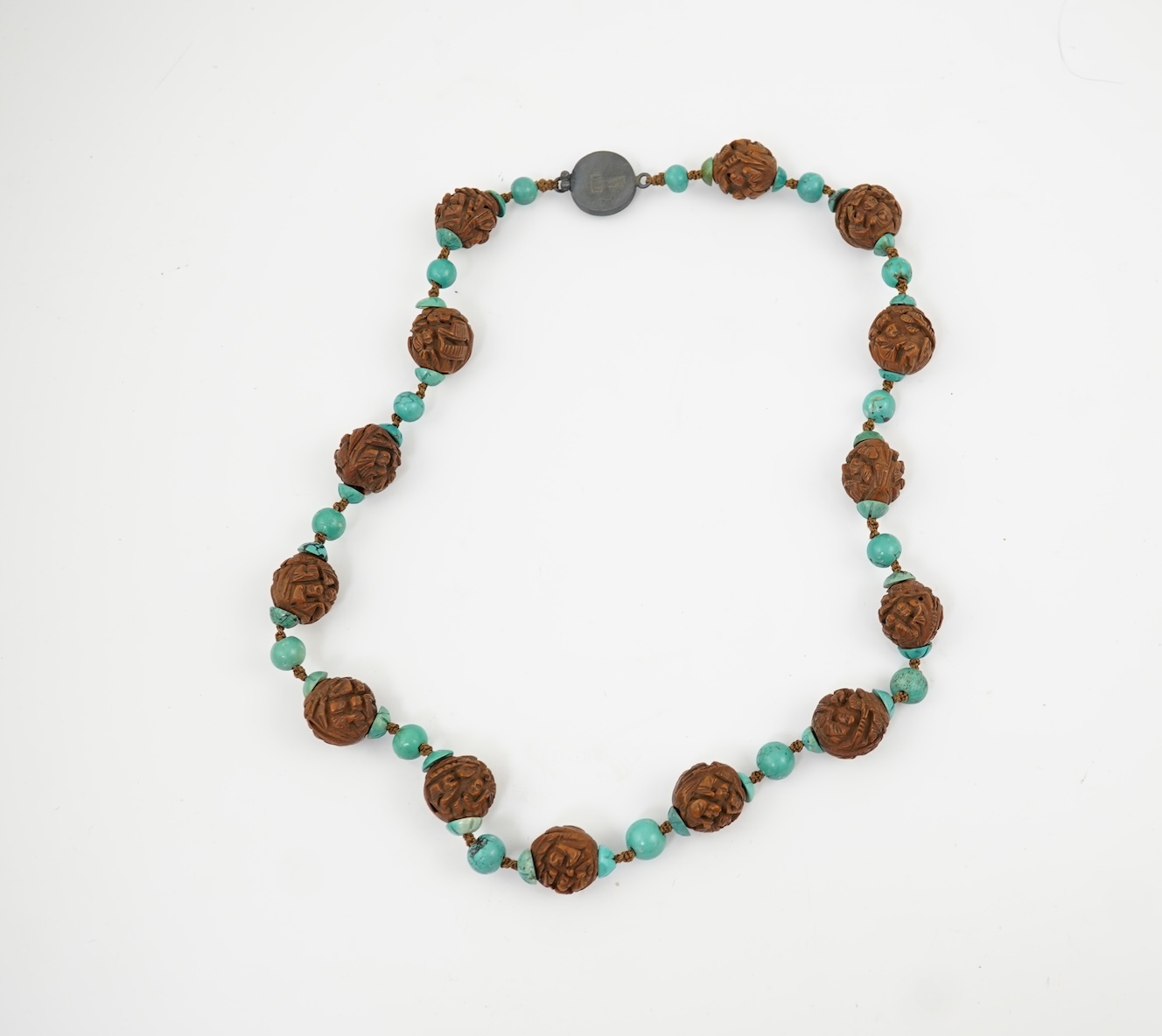 A Chinese silver filigree work and enamel scent bottle, by Wongshing, three carved peach stones, and a kernel and turquoise bead necklace, late 19/early 20th century